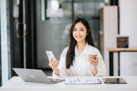 Photo for Young Asian businesswoman working on laptop in the office - Royalty Free Image