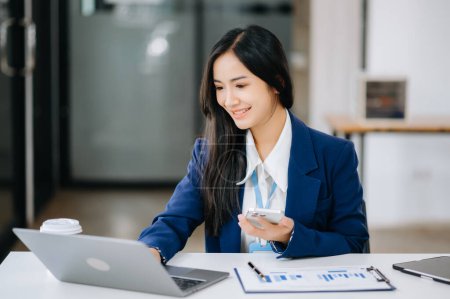 Téléchargez les photos : Jeune femme d'affaires asiatique travaillant sur ordinateur portable dans le bureau - en image libre de droit
