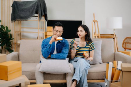 Téléchargez les photos : Asiatique jeune attrayant couple homme et femme avoir déjeuner dans nouvelle maison - en image libre de droit