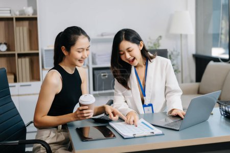 Téléchargez les photos : Deux femmes d'affaires asiatiques discutent du projet d'investissement, de la stratégie de travail et de planification avec ordinateur portable dans un bureau moderne - en image libre de droit