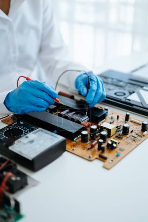 Photo for Electronics technician, engineering electronic repair,electronics measuring and testing, repair and maintenance concepts.uses a voltage meter to check and upgrade in workshop - Royalty Free Image