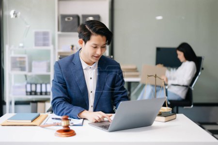 Téléchargez les photos : Asiatique homme avocat travaillant sur ordinateur portable dans le bureau, Conseil justice et droit concept - en image libre de droit