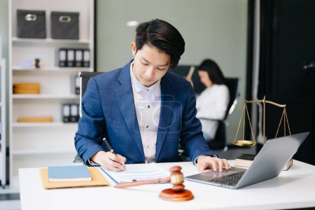 Téléchargez les photos : Asiatique homme avocat travaillant sur ordinateur portable dans le bureau, Conseil justice et droit concept - en image libre de droit
