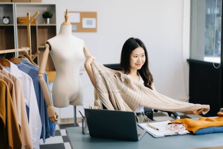 Téléchargez les photos : Concept de blogueur de mode, Jeune femme asiatique vendant des vêtements en streaming vidéo. Création de petites entreprises PME - en image libre de droit