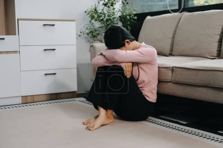 Photo for Asian woman feeling depression sitting on the floor at the sofa in the house - Royalty Free Image