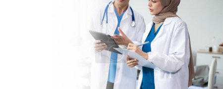 Photo for Hospital Ward. Doctor Talks With Professional Head Nurse or Surgeon, They Use Digital tablet Computer. Diverse Team of Health Care in hospital - Royalty Free Image