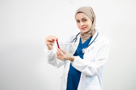 Téléchargez les photos : Arabe musulman. Femme médecin tenant échantillon avec du sang sur fond blanc isolé en studio - en image libre de droit