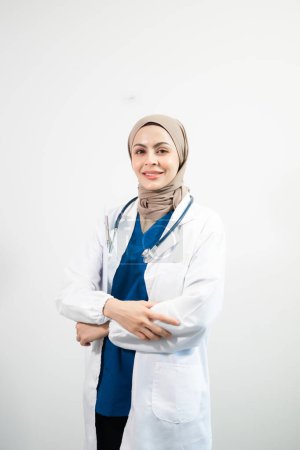Téléchargez les photos : Arabe musulman. Médecin femme avec les mains croisées sur fond blanc isolé en studio - en image libre de droit