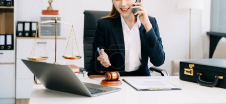 Téléchargez les photos : Belle avocate asiatique travaillant au bureau et utilisant un smartphone, Conseils justice et concept de droit - en image libre de droit