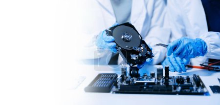 Photo for Technicians repairing inside of hard disk drive - Royalty Free Image
