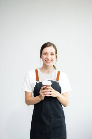 Foto de Mujer empresaria caucásica en delantal o dueño de tienda Aislado sobre fondo blanco con taza de café en las manos - Imagen libre de derechos