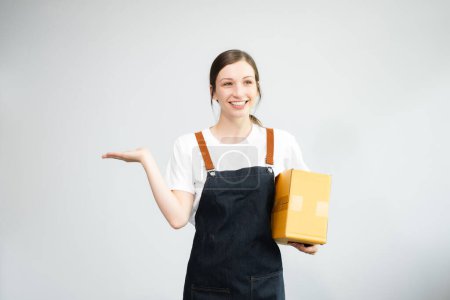 Photo for Caucasian woman smiling and holding package parcel box, holding hand with copy space isolated on white background, Delivery courier and shipping service concept - Royalty Free Image