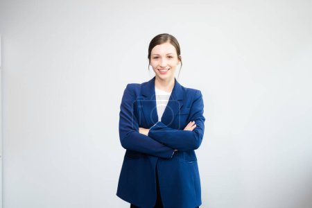 Foto de Joven mujer de negocios exitosa en traje cruzando brazos aislados sobre fondo blanco en estudio - Imagen libre de derechos