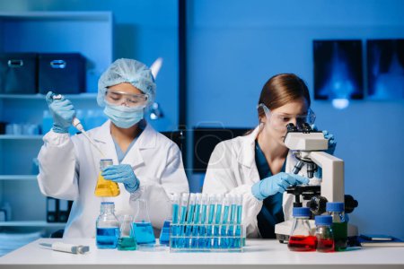 Jeunes scientifiques menant des recherches dans un laboratoire médical, chercheurs utilisant un microscope en laboratoire de médecine.  