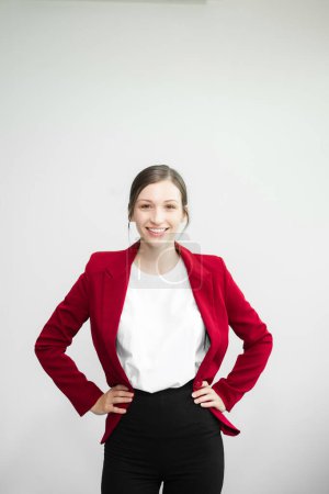 Foto de Exitosa empresaria en traje rojo aislada sobre fondo blanco y cogida de la mano en las caderas - Imagen libre de derechos