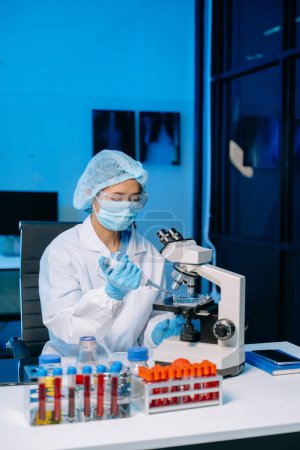 Foto de Laboratorio de investigación médica moderna. científica femenina que trabaja con micropipetas analizando muestras bioquímicas, laboratorio químico de ciencia avanzada - Imagen libre de derechos