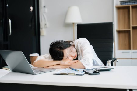 Téléchargez les photos : Une femme d'affaires surmenée qui dormait après a eu une longue journée au bureau. concept de syndrome de bureau - en image libre de droit