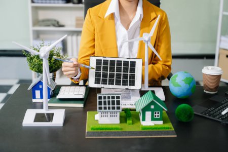 Téléchargez les photos : Businesswoman mains présentant le projet d'énergie verte pour l'immobilier - en image libre de droit