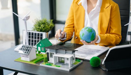 Téléchargez les photos : Businesswoman mains présentant le projet d'énergie verte pour l'immobilier - en image libre de droit