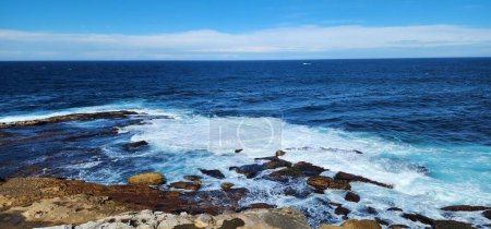 Foto de Escena natural junto al mar, vista del cielo y el horizonte marino en una costa rocosa en Maroubra Beach, Sydney. Playa fotografiada desde lo alto de los acantilados. - Imagen libre de derechos
