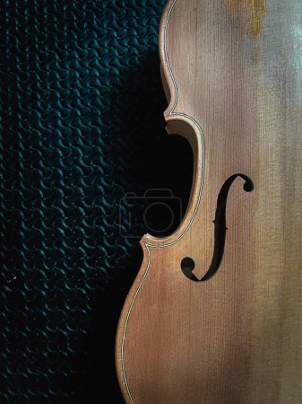 Foto de Medio lado delantero de Violín crudo de madera con agujero en F, colocado en el lado derecho sobre fondo, instrumento acústico - Imagen libre de derechos