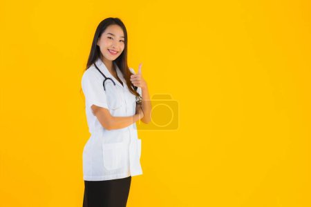 Photo for Portrait beautiful young asian doctor woman smile happy work in hospital and clinic on yellow isolated background - Royalty Free Image