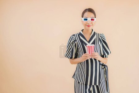 Foto de Retrato hermosa joven mujer asiática con gafas 3D sobre fondo marrón - Imagen libre de derechos