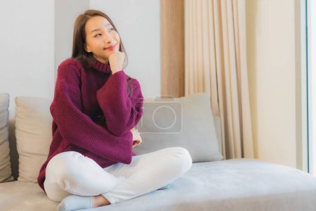 Photo for Portrait beautiful young asian woman smile relax on sofa in living room interior - Royalty Free Image