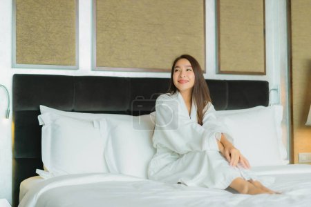 Photo for Portrait beautiful young asian woman smile relax on bed in bedroom interior - Royalty Free Image