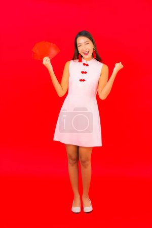 Téléchargez les photos : Portrait belle jeune femme asiatique avec enveloppe rouge lettre sur fond rouge - en image libre de droit