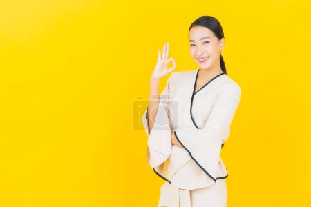 Foto de Retrato hermosa joven negocio asiático mujer con sonrisa y acción amarillo fondo - Imagen libre de derechos