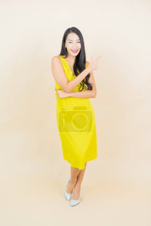 Foto de Retrato hermosa joven asiática mujer sonrisa con acción en crema fondo - Imagen libre de derechos