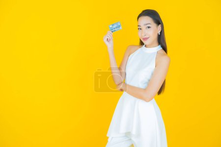Foto de Retrato hermosa joven asiática mujer sonrisa con tarjeta de crédito en color de fondo - Imagen libre de derechos
