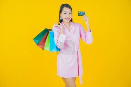 Foto de Retrato hermosa joven mujer asiática sonrisa con bolsa de compras en el fondo de color - Imagen libre de derechos