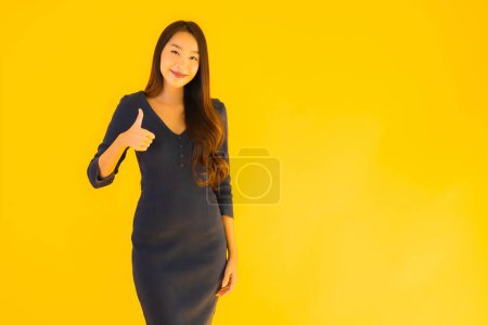 Téléchargez les photos : Portrait belle jeune femme asiatique avec action sur fond jaune isolé - en image libre de droit