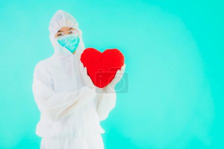 Photo for Portrait beautiful young asian doctor woman wear ppe or  personal protective equipment for protect from coronavirus or covid19 show heart on blue isolated background - Royalty Free Image