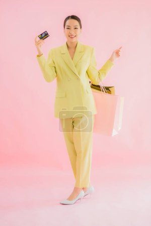 Foto de Retrato hermosa joven mujer de negocios asiática con bolsa de compras en color aislado fondo - Imagen libre de derechos