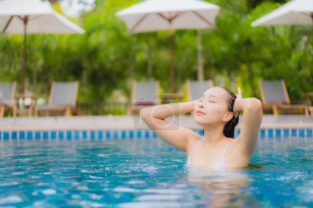 Photo for Portrait beautiful young asian woman smile relax around outdoor swimming pool in resort hotel on holiday vacation travel trip - Royalty Free Image