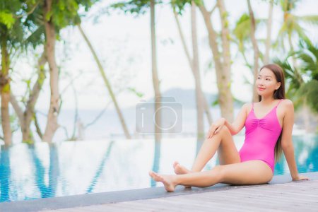 Foto de Retrato hermosa joven mujer asiática sonrisa relajarse alrededor de la piscina al aire libre en hotel resort en vacaciones viaje de vacaciones - Imagen libre de derechos