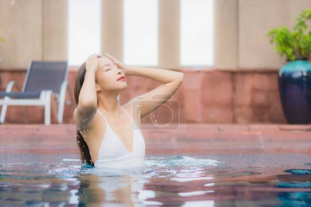 Téléchargez les photos : Portrait belle jeune femme asiatique relax sourire loisirs autour de la piscine extérieure à l'hôtel et station balnéaire - en image libre de droit