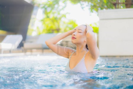 Photo for Portrait beautiful young asian woman smile relax leisure around swimming pool for vacation - Royalty Free Image