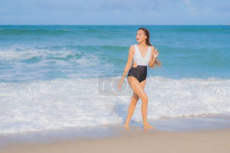 Téléchargez les photos : Portrait belle jeune femme asiatique se détendre sourire autour de la plage mer océan en vacances - en image libre de droit