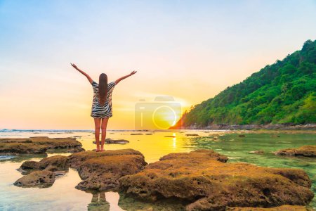 Photo for Portrait asian woman stand on the rock at sunset around beach sea ocean in travel vacation trip - Royalty Free Image