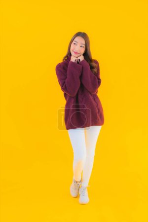 Téléchargez les photos : Portrait belle jeune femme asiatique sourire heureux dans une autre action sur fond jaune isolé - en image libre de droit