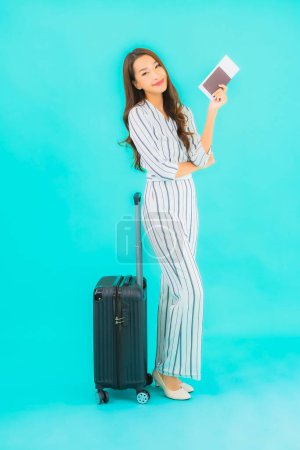 Foto de Retrato hermosa joven asiática mujer con pasaporte de equipaje y tarjeta de embarque listo para viajar sobre fondo azul - Imagen libre de derechos