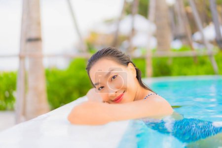 Photo for Portrait beautiful young asian woman relax leisure around outdoor swimming pool with sea ocean beach - Royalty Free Image