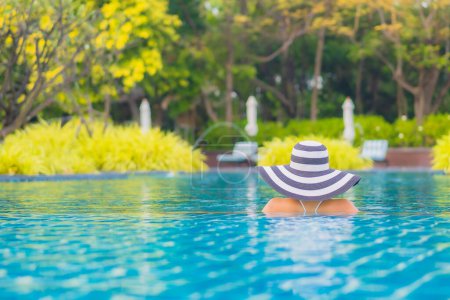 Foto de Retrato hermosa joven asiática mujer relajarse sonrisa ocio alrededor al aire libre piscina casi mar playa océano para vacaciones vacaciones - Imagen libre de derechos