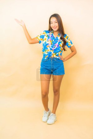 Foto de Retrato hermosa joven asiática mujer desgaste colorido camisa para songkran festival en color fondo - Imagen libre de derechos