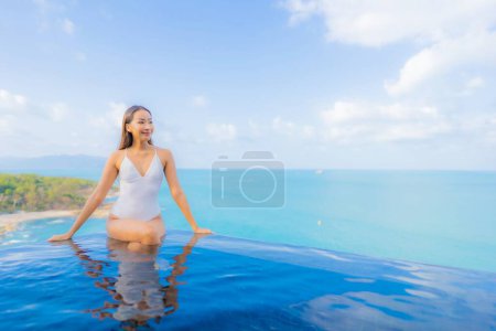 Photo for Portrait beautiful young asian woman relax smile leisure around outdoor swimming pool with sea ocean in travel vacation - Royalty Free Image