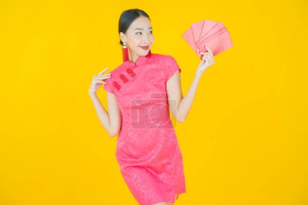Téléchargez les photos : Portrait belle jeune femme asiatique avec enveloppe rouge sur fond de couleur - en image libre de droit